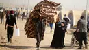 Seorang pria bersama keluarganya membawa kasur menuju kamp pengungsian Khazer, Irak(28/11). Mereka meningglkan daerah yang menjadi kawasan perang antara Pasukan Irak dan ISIS ke tempat yang lebih aman. (Reuters/Mohammed Salem)