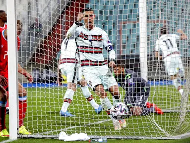 Ekspresi pemain Portugal Cristiano Ronaldo (tengah) saat rekan setimnya Joao Palhinha (kedua kanan) mencetak gol ke gawang Luksemburg pada pertandingan Grup A kualifikasi Piala Dunia 2022 di Stadion Josy Barthel, Luksemburg, Selasa (30/3/2021). Portugal menang 3-1. (AP Photo/Olivier Matthys)