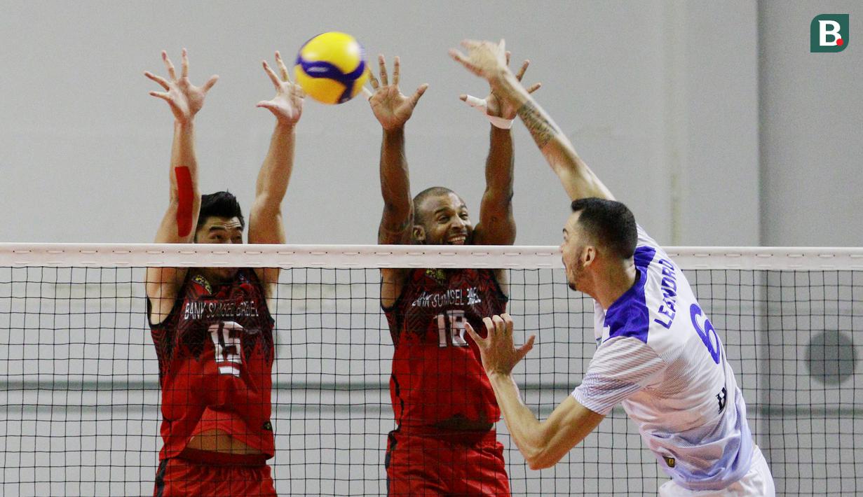 Pemain Palembang Bank Sumsel Babel, Gunawan Saputra (Kiri) dan Caio Alexandre berusaha memblok bola smes pemain Bogor LavAni, Leandro pada laga PLN Mobile Proliga 2022 di Padepokan Voli Jenderal Polisi Kunarto, Sentul, Sabtu (29/1/2022). (Bola.com/M Iqbal Ichsan)