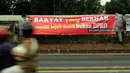 Beberapa aktivis membentang spanduk di pagar jalan tol dalam kota persis di depan gedung DPR RI, Jakarta, (14/10/2014). (Liputan6.com/Helmi Fithriansyah)