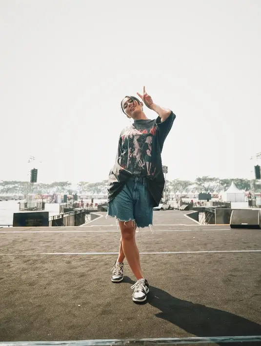 Agnez Mo tampil santai dengan oversized graphic shirt dan celana pendek jeans sebelum manggung [@agnezmo]