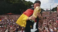 Pemain belakang Timnas Jerman, Benedikt Hoewedes, mencium trofi Piala Dunia saat perayaan kemenangan Der Panzer di Berlin, (15/7/2014). (REUTERS/Alex Grimm/Pool) 