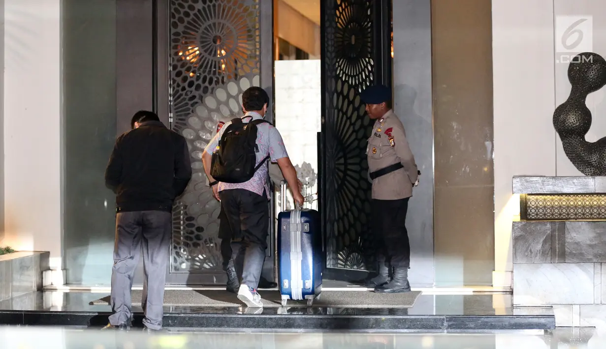 Dua penyidik KPK masuk ke dalam rumah tersangka Ketua DPR RI Setya Novanto dengan membawa tas koper biru di Jalan Wijaya 13 No 19, Jakarta Selatan, Rabu (15/11). (Liputan6.com/Johan Tallo)