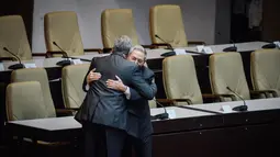 Miguel Díaz-Canel memeluk Presiden Kuba sebelumnya, Raul Castro usai terpilih sebagai Presiden baru Kuba di Majelis Nasional, Havana, Kamis (19/4). Díaz-Canel, dipilih dengan suara 603-1 untuk menggantikan Raul Castro (86). (Adalberto Roque/Pool via AP)