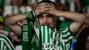 Seorang suporter Real Betis memegang kepalanya sambil meneteskan air mata sebagai bentuk kecewa atas kekalahan timnya dalam laga final UEFA Conference League melawan Chelsea di Tarczynski Arena, Wroclaw, Polandia, Kamis (29/05/2025) dini hari WIB. (AFP/Cristina Quicler)