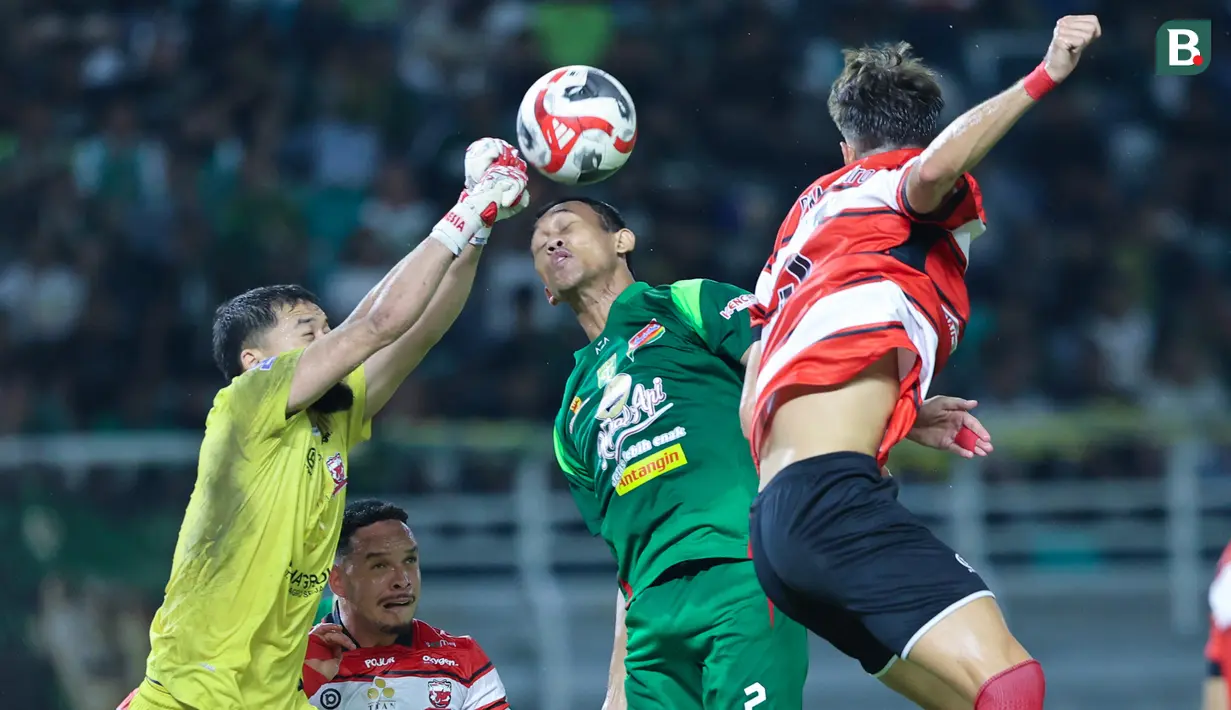 Kiper Madura United, Diky Indriyana, berusaha menghalau bola saat melawan Persebaya Surabaya pada laga BRI Super League di Stadion Gelora Bung Tomo, Surabaya, Jumat (17/04/2026). (Bola.com/M Iqbal Ichsan)
