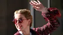 Aktris AS Amber Heard menyapa penggemarnya saat tiba untuk menghadiri malam pembukaan Festival Film Cannes ke-72 di Hotel Martinez, Prancis (13/5/2019). Aktris 33 tahun ini mengenakan kaca mata merah, perhiasan emas, dan membawa tas rantai-tali YSL. (AFP Photo/Alberto Pizzoli)