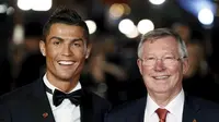 Penyerang Real Madrid, Cristiano Ronaldo bersama Sir Alex Ferguson tersenyum saat difoto dalam pemutaran film perdana 'Ronaldo' di Leicester Square, London, Inggris (9/11). (Reuters/Stefan Wermuth)
