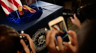 Awak media mengambil gambar sepatu ruby yang pernah dikenakan aktris Judy Garland dalam "The Wizard of Oz" di Kantor FBI, Minnesota, Selasa (4/9). Sepatu ini pernah dicuri pada 2005 dari Judy Garland Museum. (Richard Tsong-Taatarii/Star Tribune via AP)