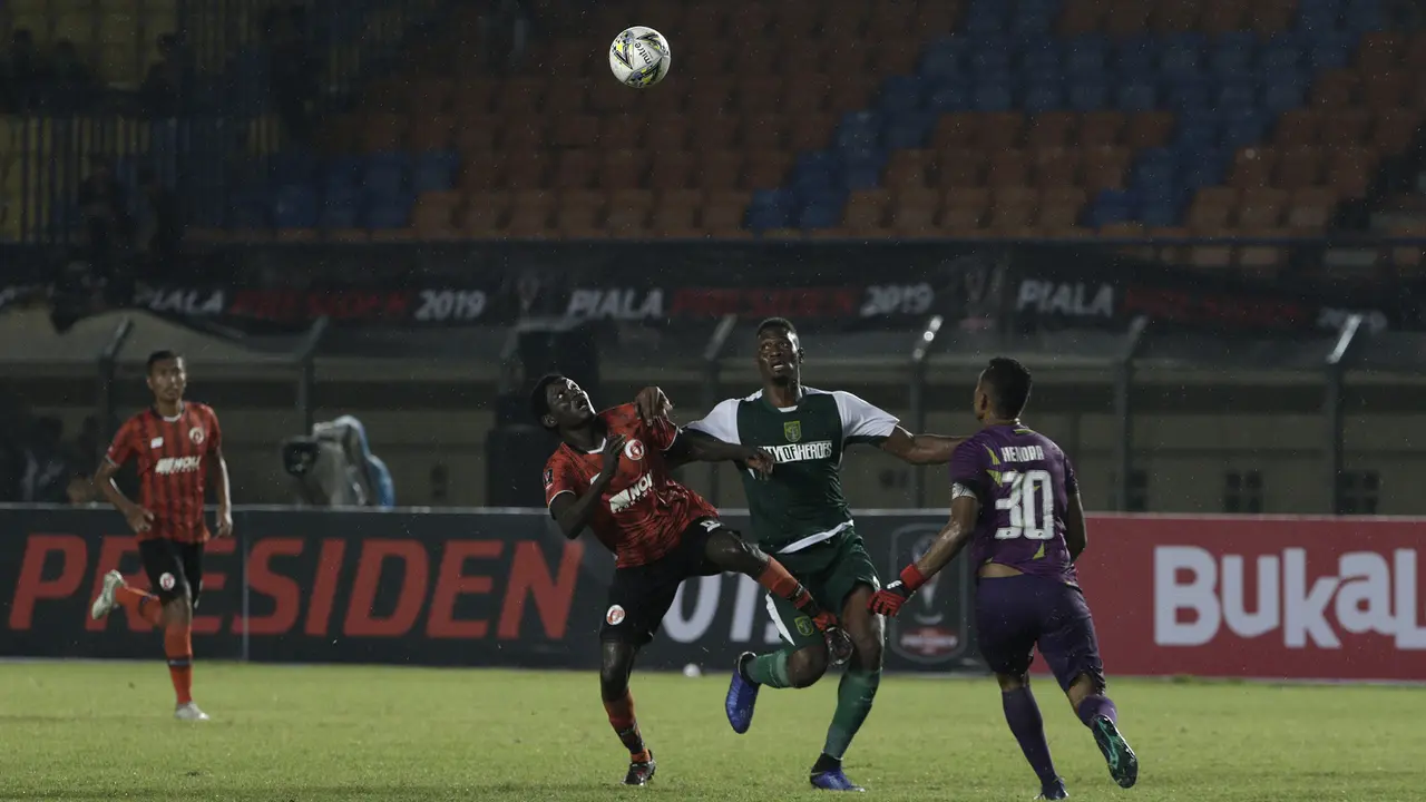 Striker Persebaya Surabaya, Amido Balde, berebut bola dengan bek Perseu Serui, Diakite Seydou, pada laga Piala Presiden 2019. (Bola.com/Yoppy Renato)