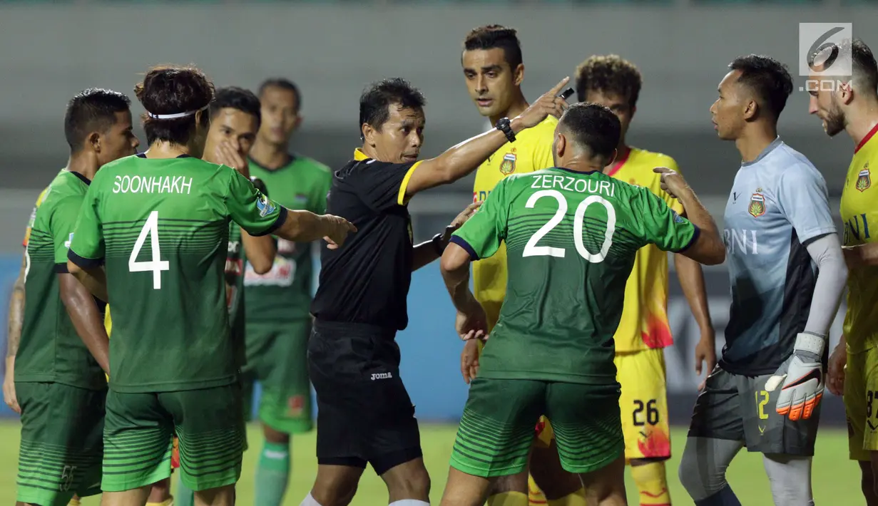 Pemain PS TNI dan Bhayangkara FC melakukan protes kepada wasit Djumadi Effendi (tengah) saat lanjutan Liga 1 Indonesia di Stadion Pakansari, Kab Bogor, Minggu (3/9). Bhayangkara FC unggul 1-0. (Liputan6.com/Helmi Fithriansyah)