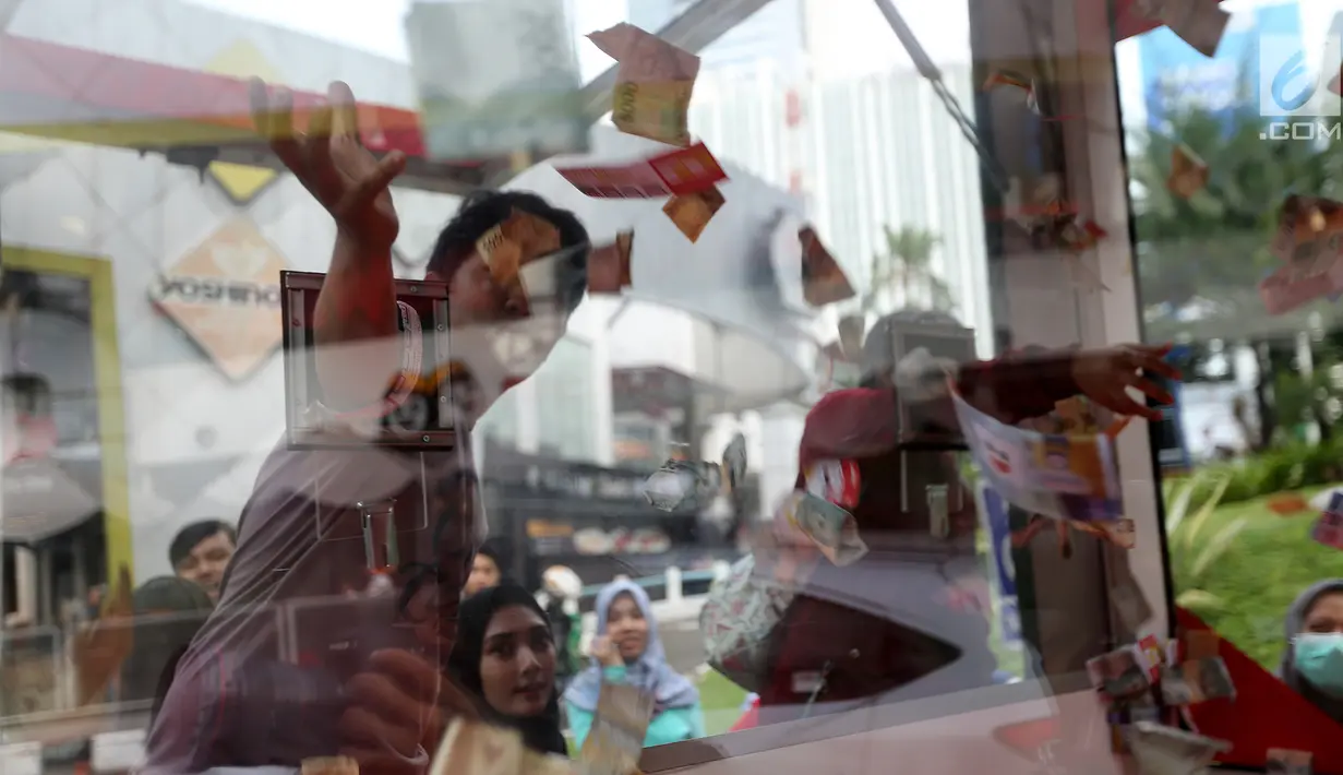 Pengunjung memasukan tangan untuk mendapatkan uang secara cuma-cuma ke dalam mobil boks Shopback di Plaza Festival  Kuningan, Jakarta, Kamis (24/5). Mereka rela antri sambil menunggu waktu berbuka puasa. (Liputan6.com/Fery Pradolo)