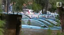 Sejumlah taksi terendam banjir di Pool Taksi Bluebird kawasan Kramat Jati, Jakarta, Selasa (25/2/2020). Meluapnya Kali Cipinang membuat Pool Taksi Blue Bird yang berada tepat di samping kali ikut terdampak banjir. (Liputan6.com/Herman Zakharia)