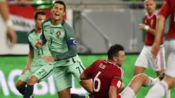 Striker Portugal, Cristiano Ronaldo, terjatuh saat dilanggar pemain Hongaria, Akos Elek, pada laga Kualifikasi Piala Dunia 2018 di Stadion Groupama, Minggu (3/9/2017). Portugal menang 1-0 atas Hongaria. (AP/Tibor Illyes)