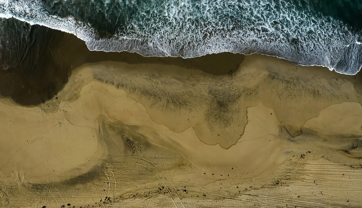 Foto udara menunjukkan pantai tercemar tumpahan minyak di Huntington Beach, California, Amerika Serikat, 4 Oktober 2021. Tumpahan minyak menyebabkan ikan dan burung mati berserakan. (AP Photo/Ringo H.W. Chiu)