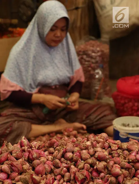 Pedagang mengupas bawang merah yang akan dijual di Pasar Induk Kramat Jati, Jakarta, Selasa (2/4/2019). Sejumlah pedagang di Pasar Induk Kramat Jati mengaku harga bawang merah dan bawang putih relatif stabil, meskipun terjadi kenaikan harga di beberapa daerah. (Liputan6.com/Immanuel Antonius)
