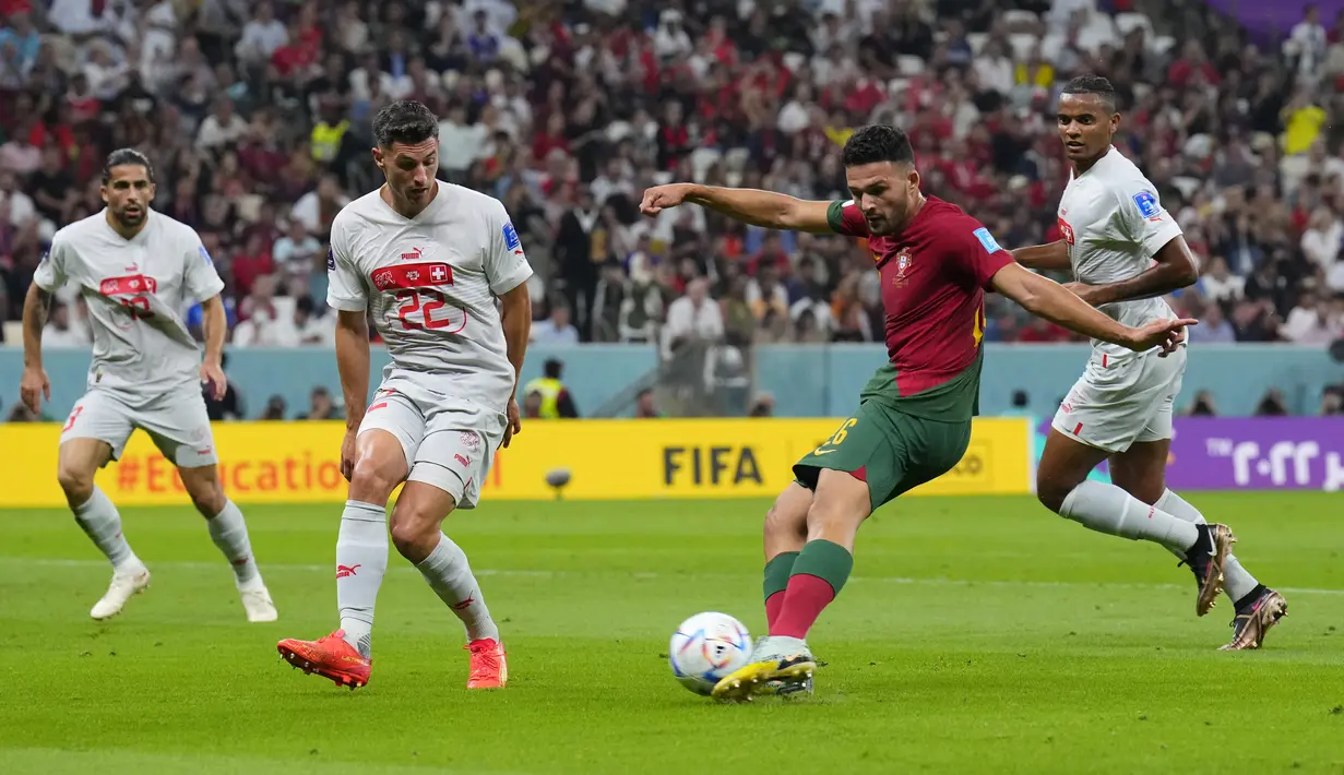 Penyerang Portugal Goncalo Ramos menembak dan mencetak gol ke gawang Swiss dalam laga 16 besar Piala Dunia 2022 di Stadion Lusail Iconic, Rabu (7/12/2022) dini hari WIB. Dalam pertandingan ini, striker muda Benfica, Goncalo Ramos jadi bintang kemenangan setelah menjawa kepercayaan besar pelatih Fernando Santos menggantikan Cristiano Ronaldo di depan. (AP Photo/Natacha Pisarenko)