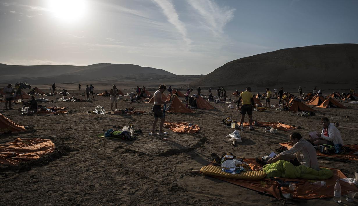 Para peserta beristirahat dengan tenda saat mengikuti lomba marathon sejauh 250 kilometer di Gurun Ica, Kamis (30/11/2017). Marathon yang terbagi dalam enam tahapan ini diprediksi akan berakhir pada 4 Desember. (AFP/Jean-Philippe Ksiazek)