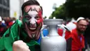 Seorang penggemar Italia merayakan dengan replika trofi sebelum pertandingan sepak bola Euro 2024 Grup B antara Italia dan Albania di BVB Stadion di Dortmund, Jerman barat, pada 15 Juni 2024. (FRANCK FIFE/AFP)