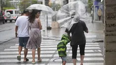 Orang-orang menyusuri jalan tempat wisata yang terkenal "Kokusai-dori" saat badai tropis mendekat di Naha, Pulau Okinawa, Jepang, Kamis (1/6/2023). (AP Photo/Hiro Komae)