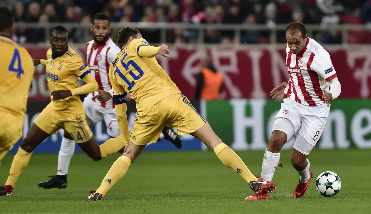Gelandang Olympiakos, Vadis Odjida, berusaha melewati bek Juventus, Andrea Barzagli, pada laga Liga Champions di Stadion Georgios Karaiskakis, Rabu (6/12/2017). Juventus menang 2-0 atas Olympiakos.(AFP/Louisa Gouliamaki)