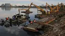 Sejumlah pekerja  saat bersiap melakukan pengerukan sampah di Waduk Pluit, Jakarta, Kamis (30/4/2015). Pengerukan waduk pluit  dilakukan selain untuk mengurangi sampah - sampah di waduk juga untuk keindahan waduk. (Liputan6.com/JohanTallo)