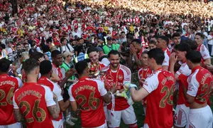 Para pemain Arsenal berdiri dengan trofi Liga Premier setelah upacara penyerahan di lapangan setelah pertandingan Liga Inggris antara Crystal Palace dan Arsenal di Selhurst Park di London selatan pada 24 Mei 2026. Arsenal menjadi juara liga Inggris untuk pertama kalinya sejak 2004, memenangkan liga dengan selisih tujuh poin. (Adrian Dennis/AFP)