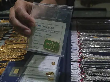Pedagang menunjukan emas batangan 10 gram di pusat penjualan emas kawasan Cikini, Jakarta, Senin (12/10/2015). Harga emas yang dijual PT Antam Tbk hari ini turun Rp11.000 ke Rp556.000 per gram dari sebelumnya Rp567.000 per gram.(Liputan6.com/Angga Yuniar)