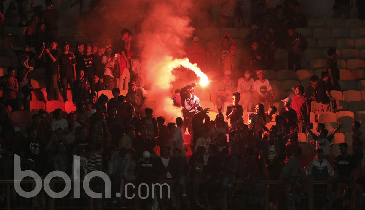 Suporter menyalakan flare saat memberikan dukungan kepada pemain Timnas Indonesia U-16 saat pertandingan melawan Singapura pada laga uji coba di Stadion Wibawa Mukti, Cikarang, Kamis, (8/6/2017). Indonesia menang 4-0. (Bola.com/M Iqbal Ichsan)