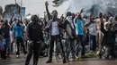 Pendukung kandidat oposisi Gabon, Jean Ping, yang berdemonstrasi dihalangi pasukan keamanan saat mencoba masuk markas komisi pemilihan di Libreville, Rabu (31/8). Demonstrasi meletus setelah Presiden Gabon, Ali Bongo terpilih kembali. (MARCO LONGARI/AFP)