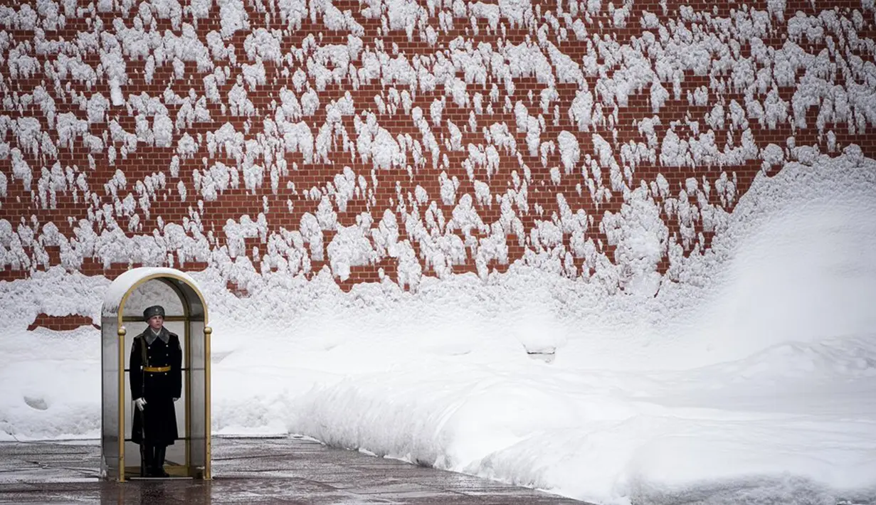 Seorang prajurit berdiri menjaga Makam Prajurit Tak Dikenal setelah hujan salju di Tembok Kremlin, Moskow, Rusia, 7 Februari 2022. (AP Photo/Alexander Zemlianichenko)