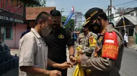 Polisi memberikan imbauan dan masker gratis kepada warga Bekasi yang tidak menerapkan protokol kesehatan. (Liputan6.com/Bam Sinulingga)