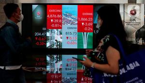 Pekerja tengah melintas di bawah layar Indeks harga saham gabungan (IHSG) di BEI, Jakarta, Selasa (16/5/2023). (Liputan6.com/Angga Yuniar)