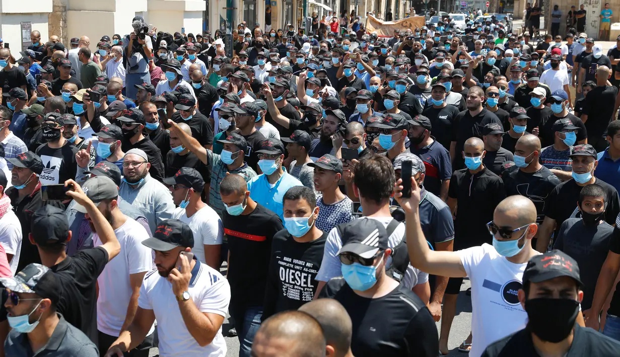 Warga saat menggelar aksi protes di kota pesisir Mediterania, Jaffa, Tel Aviv selatan (26/6/2020). Gelombang aksi protes tersebut terlihat memenuhi sebuah jalan di kota Jaffa, Tel Aviv. (AFP Photo/Jack Guez)