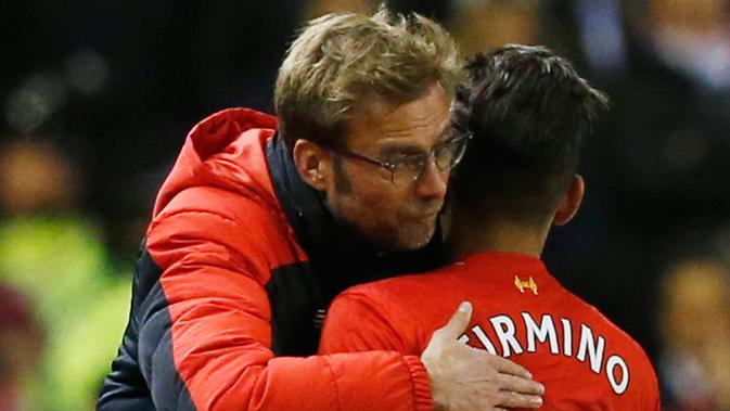 Striker Liverpool, Roberto Firmino berpelukan dengan sang pelatih, Jurgen Klopp. (Foto: AFP)