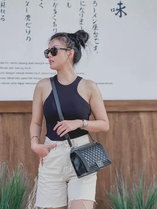 Kasual dengan halter top dan celana khaki, penampilan Nita Gunawan menjadi lebih kece dengan Chanel Boy berwarna hitam. (instagram/nitagunawan09)