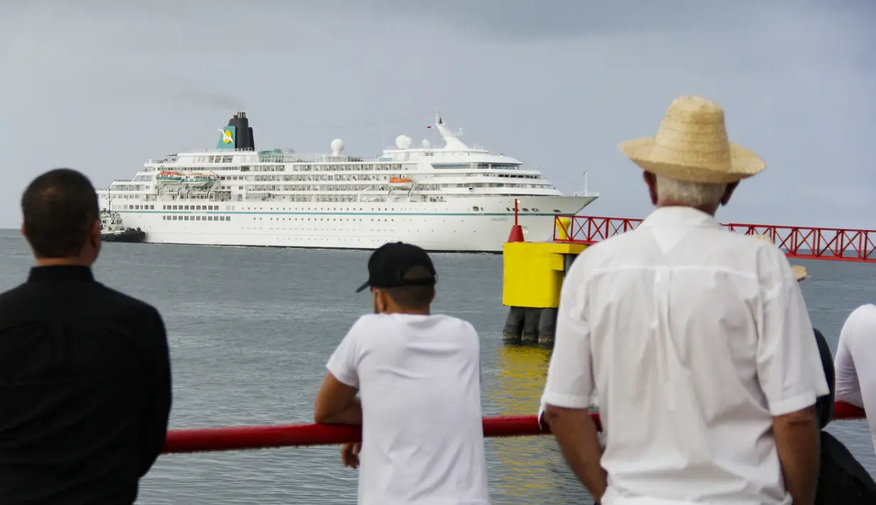 Warga menyaksikan kedatangan kapal pesiar MS Amadea dengan sekitar 500 turis dari berbagai negara Eropa di pelabuhan El Guamache di Isla Margarita, negara bagian Nueva Esparta, Venezuela (3/1/2023). Kapal pesiar Jerman MS Amadea adalah yang pertama tiba di Venezuela Pulau Karibia setelah 15 tahun. (AFP/Gustavo Granado)