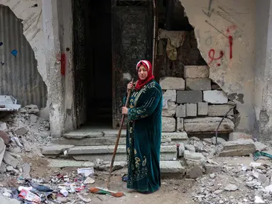Shahira Sammour, 49 tahun, berpose di depan rumahnya yang hancur di Jabalia, Jalur Gaza utara, pada 9 Februari 2025. (Bashar TALEB/AFP)