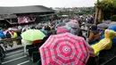 Para penonton memakai payung saat menyaksikan perempat final tunggal wanita antara Simona Halep asal Romania dan petenis Inggris Johanna Konta di sebuah layar lebar pada kejuaraan tenis Wimbledon 2017 di London (11/7). (AP Photo/Kirsty Wigglesworth)