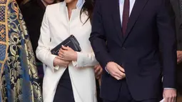 Aktris AS, Meghan Markle bersama tunangannya, Pangeran Harry menghadiri acara The Commonwealth Day Service di Westminster Abbey, London, Senin (12/3). Pada lapisan dalam coat, Meghan Markle menggunakan dress navy yang juga dari Amanda Wakeley. (AP Photo)