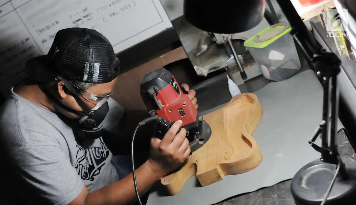 Pengrajin menghaluskan body gitar saat proses pembuatan di Syukey Guitars, Cirendeu, Ciputat Timur (3/4). Gitar ini tidak hanya dipasarkan di dalam negeri saja, tetapi juga dipasarkan hingga Amerika dan Eropa. (Merdeka.com/Arie Basuki)