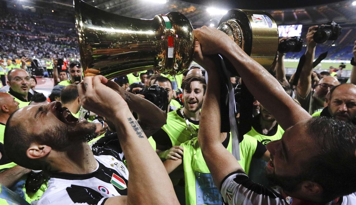 Gaya pemian Juventus, Leonardo Bonucci saat minum dari trofi juara Copaa Italia 2016-2017 usai mengalahkan Lazio di Roma Olympic stadium, (17/5/2017). Juventus menang 2-0. (AP/Gregorio Borgia)