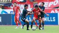 Pemain Persija Jakarta, Hanif Sjahbandi berusaha melepaskan diri dari kepungan pemain Arema FC dalam laga pekan ke-23 BRI Liga 1 2022/2023 di Stadion Patriot Candrabhaga, Bekasi, Minggu (12/2/2023) sore WIB. Persija menang dengan skor 2-0. (Bola.com/M Iqbal Ichsan)