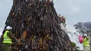 Seorang petugas menyiramkan diesel ke ratusan senjata ilegal yang akan dibakar di Kajiado County, Kenya (15/11). Kenya merupakan salah satu negara yang terkenal akan tingkat perampokan yang cukup tinggi. (AFP/Tony Karumba)