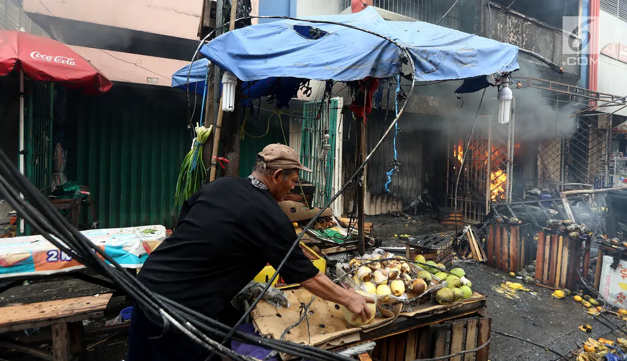Pedagang memindahkan barang dagangannya di dari lokasi kebakaran di Pasar Kebayoran Lama, Jakarta, Selasa (13/6). Kebakaran yang melanda ruko tersebut belum diketahui penyebabnya. (Liputan6.com/Johan Tallo)