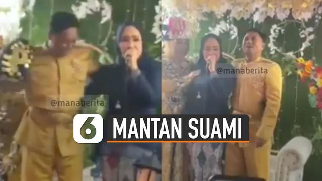 Terlihat seorang perempuan yang mengenakan kerudung menangis dan memeluk mempelai laki-laki yang berada di pelaminan.