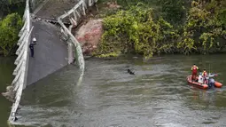 Tim penyelamat menyelam di  sungai Tarm, dekat jembatan gantung yang ambruk di Prancis, Selasa (18/11/2019). Sebanyak 60 petugas penyelamatan, 40 anggota kepolisian, 67 petugas pemadam kebakaran, dan beberapa penyelam dikerahkan untuk melakukan pencarian di dalam sungai Tarn. (ERIC CABANIS/AFP)