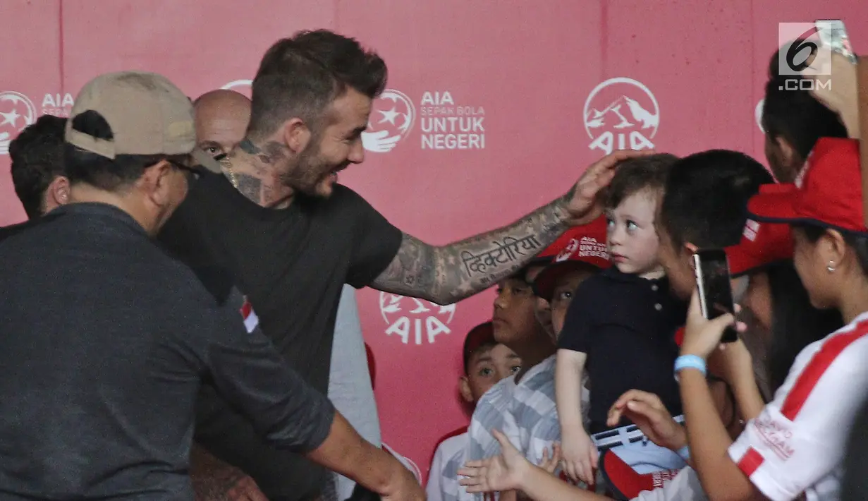 Mantan bintang sepak bola Inggris David Beckham menyapa anak-anak pada acara AIA Sepak Bola untuk Negeri di Jakarta, Minggu (25/3). Kegiatan David membagikan 10 ribu bola  untuk anak-anak memecahkan rekor MURI. (Liputan6.com/Herman Zakharia)