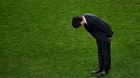 Pelatih Timnas Jepang, Hajime Moriyasu, membungkuk meminta maaf setelah timnya tersingkir di babak 16 besar Piala Dunia 2022. Jepang kalah lewat adu penalti 1-3 (1-1) melawan Kroasia di Al Janoub Stadium, Senin (5/12/2022). (AFP/Anne-Christine Poujoulat)