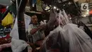 Pedagang memotong daging sapi saat melayani pembeli di Pasar Perumnas, Jakarta, Selasa (19/1/2021). Pedagang daging sapi akan mogok jualan sebagai bentuk protes kepada pemerintah karena tingginya harga daging sapi di pasar sejak awal tahun. (merdeka.com/Imam Buhori)